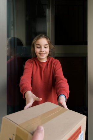 A teenage girl happily accepts a parcel from the postman. Life style