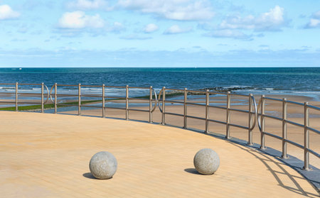 Two round stones on a public embankment with beautiful metal fencing. abstractionism in everyday lifeの写真素材