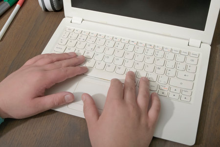 Teenager's hands on a computer keyboard. Close-up