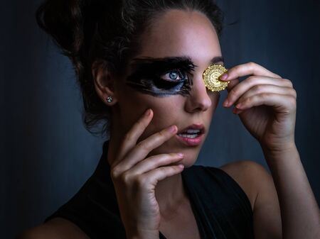 Gold coin woman black mask painted faceの写真素材