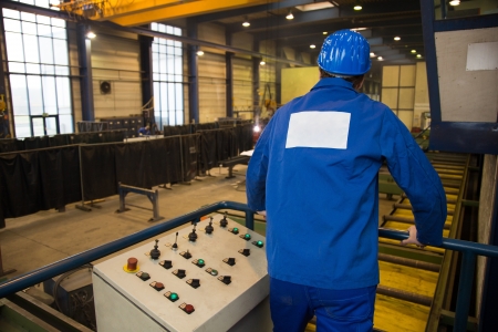 Construction worker operating a crane with a control panel