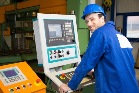 Construction worker operating a large machine with a control panel