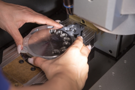 Dental technician working on a milling machineの写真素材