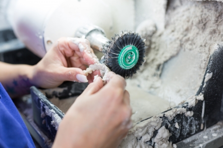 Dental technician polishing a prosthesisの写真素材