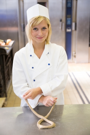 Baker forming a pretzel out of doughの写真素材