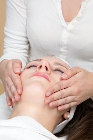 Cosmetician giving client a facial massageの写真素材