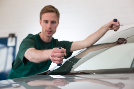 Glazier cutting adhesive of windscreen with a wire to replace windshieldの写真素材