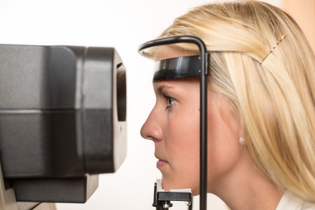 Patient and auto refractometer at optician or optometrist for scanningの写真素材