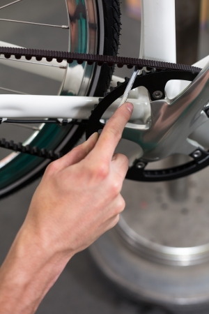 Closeup of bicycle mechanic repairing a bike in workshopの写真素材