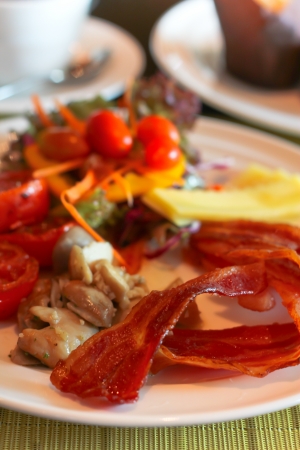 English Breakfast with grilled tomato , bacon ,mushrooms,chese and salad on Tableの写真素材