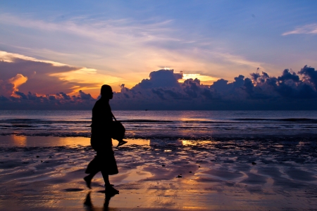 buddhist priest walk on the beach , sunrise background at Hua Hin beach ,Thailand の写真素材