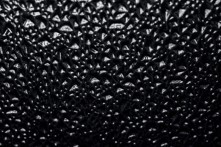 Decorative background  with a relief embossed  pattern in the form of small pits or grooves. Black and white background color with a gradient transition from light to dark, seamless  texture.の写真素材