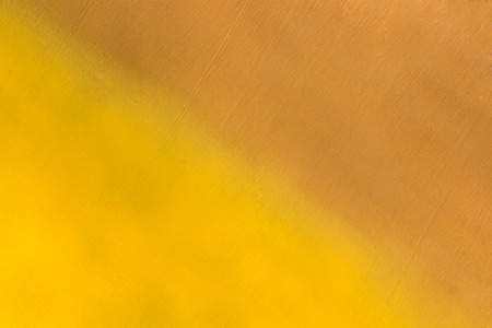 metal surface painted in yellow and brown color diagonally, background or textureの写真素材