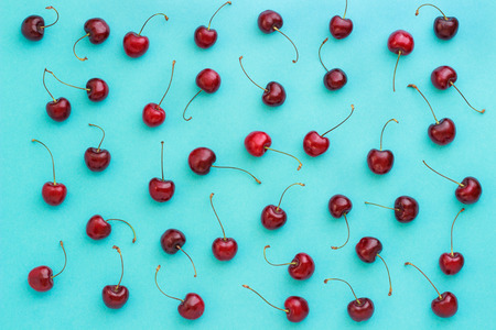 red ripe sweet cherry on blue background, Top view, Flat lay, textureの写真素材