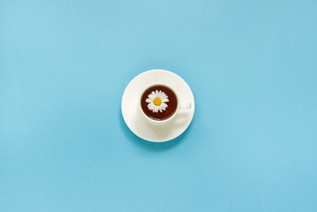 white cup of Tea Chamomile and dish saucer on blue background, Top view Copy space, Flat layの写真素材
