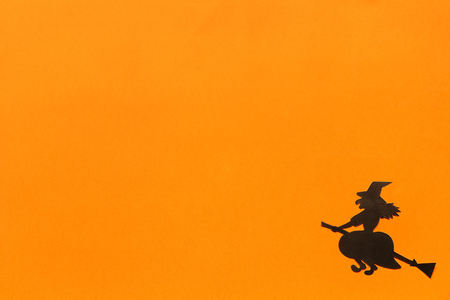 Halloween background. Black paper witch on orange background Happy halloween concept, space for text. Top view. Mockup, Layout Flat layの写真素材