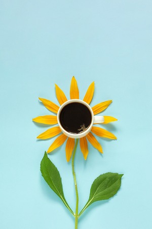 Cup of black coffee and yellow petals stalk flower shaped. Creative Flat lay Top view Copy space. Concept good morning.の写真素材