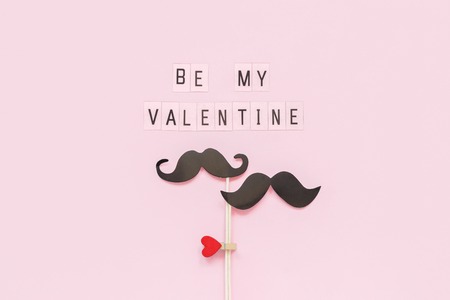 Couple paper mustache props on stick fastened clothespin heart and text Be my Valentine on pink background Concept Homosexuality gay love. Valentines Day, Valentine card Creative Top view.の写真素材