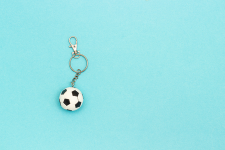 Keychain with soccer or football ball on blue background in minimal style. Top view Copy space...