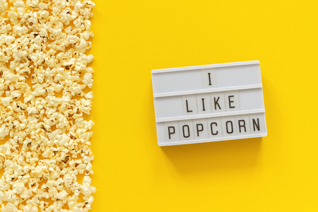 Scattered popcorn border left edge and lightbox text I like popcorn on yellow paper background. Top view Template.の写真素材