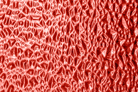 Texture of decorative glass with an abstract relief pattern colored living coral background, color of the year 2019.の写真素材