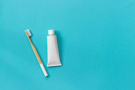 Natural eco-friendly bamboo brush with white bristles and tube of toothpaste. Set for washing on paper blue background. Copy space for text or your design Top view Flat lay.の写真素材