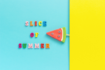 Slice of summer colorful text, pineapple and watermelon lollipops on stick on blue yellow background. Concept vacation or holidays Creative Top view Template Greeting card, postcard. Copy space.の写真素材