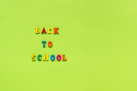 Text Back to school from multi colored letters on green paper background Concept Education Top view Copy space Template for your design.の写真素材