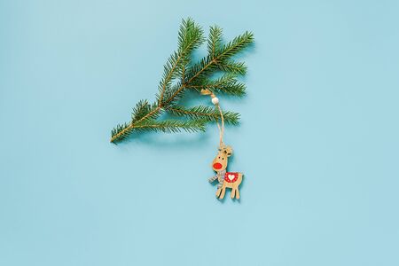 Christmas decoration deer toy on fir branch on blue background with copy space. Concept Merry christmas or Happy new year. Minimal style Top view Flat lay Template for design, card, invitation.の写真素材