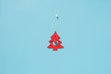 Red wood christmas decoration tree toy on blue background with copy space. Concept Merry christmas or Happy new year. Minimal style Top view Flat lay Template for your design, card, invitation.の写真素材