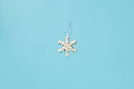 White christmas decoration snowflake toy on blue background with copy space. Concept Merry christmas or Happy new year. Minimal style Top view Flat lay Template for your design, card, invitation.の写真素材