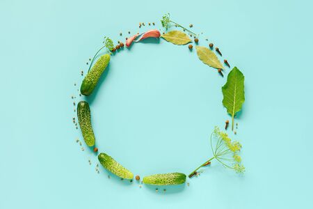Pickled cucumbers. Circle frame with copy space from ingredients for marinated gherkins on blue background. Concept culinary recipe preservation of vegetables. Creative flat lay Top view Template.の写真素材