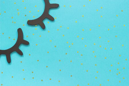 Decorative wooden black eyelashes, closed eyes and gold star on blue paper background. Concept Sweet dreams Greeting card Top view Flat lay Creative Template for design.の写真素材