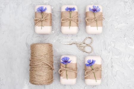 Packaging of natural handmade soap, decorated kraft paper , blue flower, skein of twine and scissors. Concept of organic cosmetics. Top view Flat lay Copy space Template for design.の写真素材