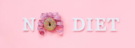 Text No diet and abstract funny face of woman from donut with eyes and hair from centimeter tape on plate on pink background. Concept International No Diet Day, 6 may Top view Flat lay Banner.の写真素材
