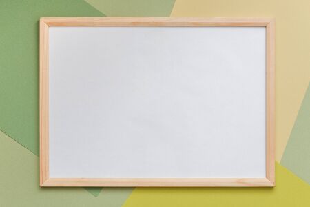 Wood blank frame on geometric green shades paper background. Copy space, mockup for your design,...