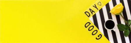 Text Good day, cup of coffee and yellow rose on stylish black and white napkin on yellow background . Concept Flat lay Top view Copy space Banner.の写真素材