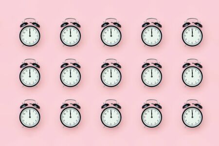 Pattern with black alarm clock on pink background. Minimal style Top view Template for your text, design.の写真素材