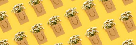 Pattern with field chamomiles flowers in craft package on yellow background. Concept Hello summer, Mother's day, Womens day, Good day Top view Flat Lay Banner.の写真素材