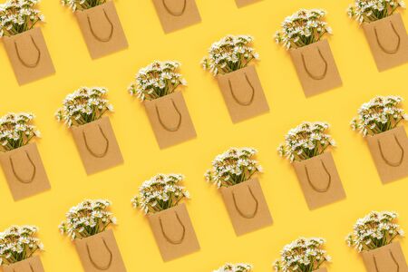 Pattern with field chamomiles flowers in craft package on yellow background. Greeting card Flat Lay Concept Hello summer, Mother's day, Womens day, Good day Template for text and design.の写真素材