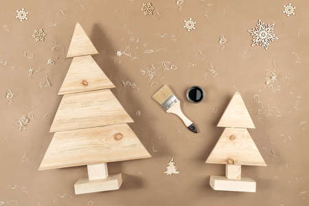 XMAS or New Year composition. Handmade wooden Christmas trees, paint, brushes on craft beige background. Concept Zero waste, eco - friendly Merry Christmas. Top view Flat lay.の写真素材