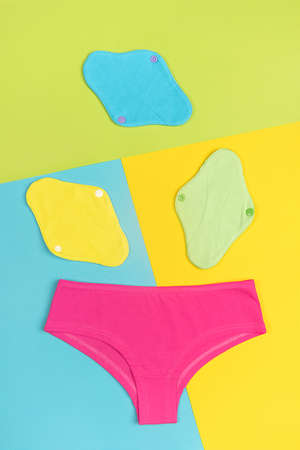 Eco sanitary reusable pads and underpants on colored background. Health care and zero-waste, no plastic concept. Top view Flat lay.の写真素材