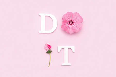 Do it. Motivational quote from white letters and beauty natural flowers on pink background. Creative concept inspirational quote of the day.の写真素材