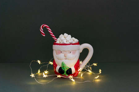 Happy Christmas or New year holiday concept. Funny santa claus cup of cocoa with marshmallows, candy...