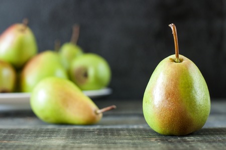 Fresh ripe pears lie on a white wooden tableの写真素材