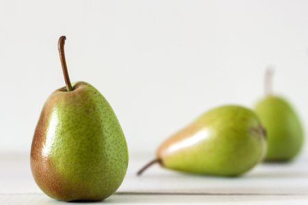 Fresh ripe pears lie on a white wooden tableの写真素材