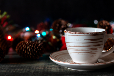 On the table is a cup of coffee on the background of New Year's garlandsの写真素材