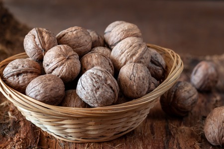 On the old wooden table are whole walnuts