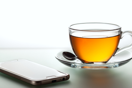 Cup of black tea and spoon, isolated on whiteの写真素材