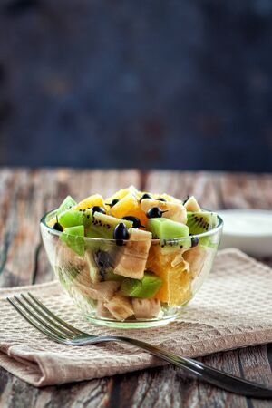 On a wooden background, fresh fruit salad for a healthy dietの写真素材